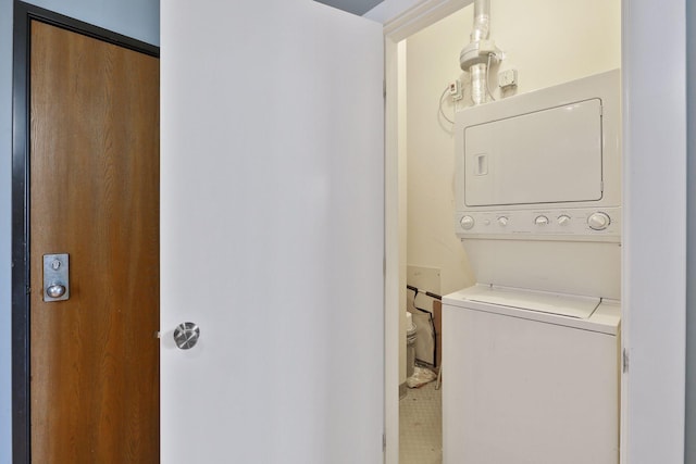 clothes washing area featuring laundry area and stacked washer / dryer