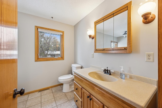 half bath featuring vanity, baseboards, visible vents, tile patterned floors, and toilet