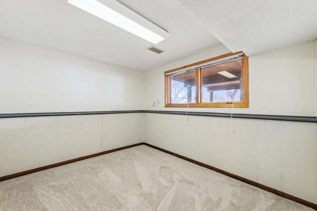 empty room with visible vents, baseboards, and carpet flooring