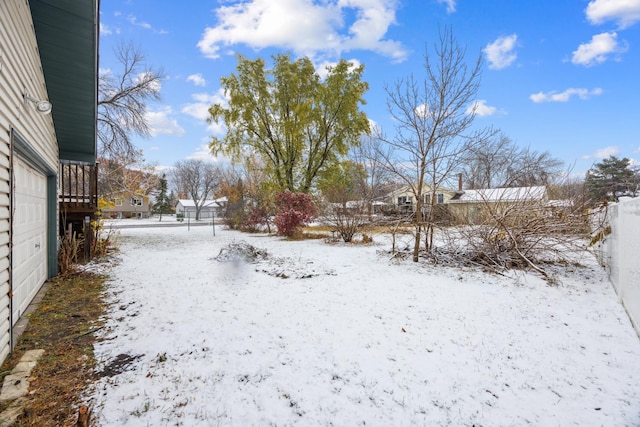 yard layered in snow featuring a garage