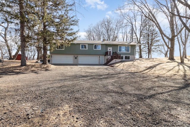 split foyer home featuring a garage, brick siding, and driveway