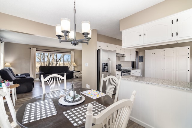 dining space with dark wood-style floors and a notable chandelier