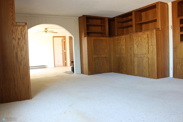 203 4th St, Argusville, ND 58005 - unfurnished bedroom with carpet floors, arched walkways, a baseboard radiator, and a closet