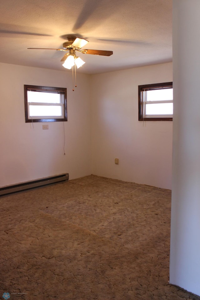 203 4th St, Argusville, ND 58005 - unfurnished room featuring healthy amount of natural light, a baseboard heating unit, ceiling fan, and carpet