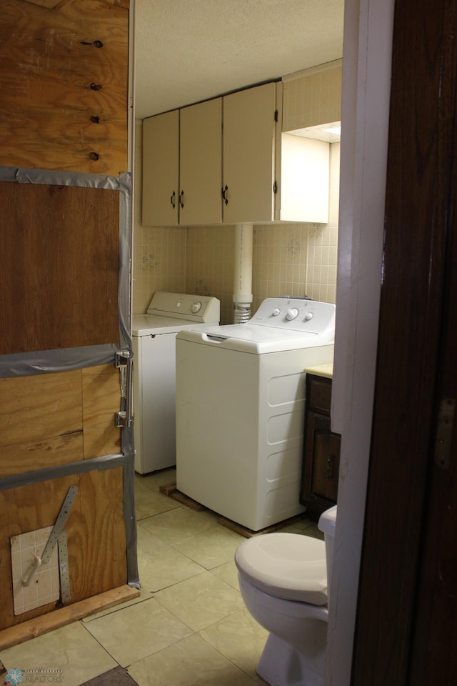 203 4th St, Argusville, ND 58005 - laundry room featuring washing machine and clothes dryer, cabinet space, and light tile patterned floors