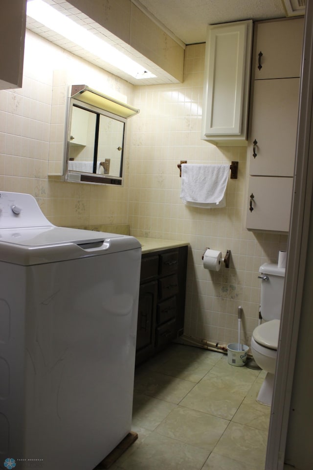 203 4th St, Argusville, ND 58005 - bathroom with washer / clothes dryer, tile walls, tile patterned floors, and toilet