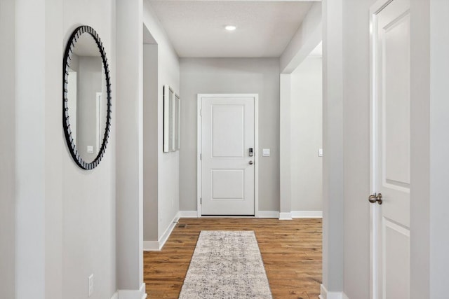 hallway featuring baseboards and wood finished floors