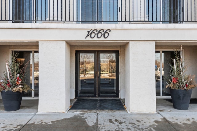 view of exterior entry with stucco siding and french doors