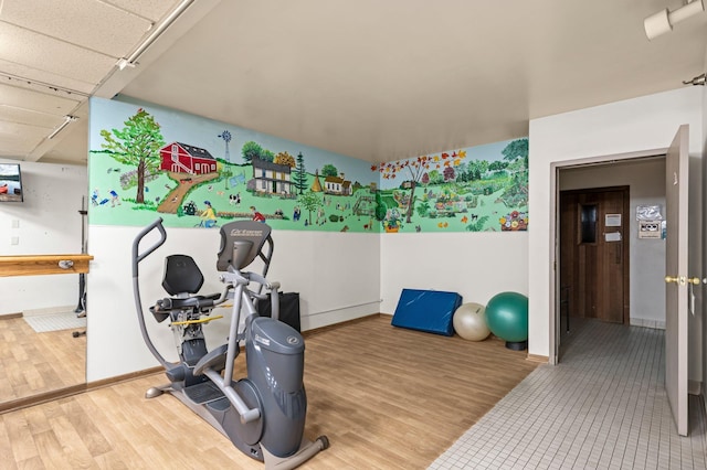 exercise room featuring baseboards and wood finished floors