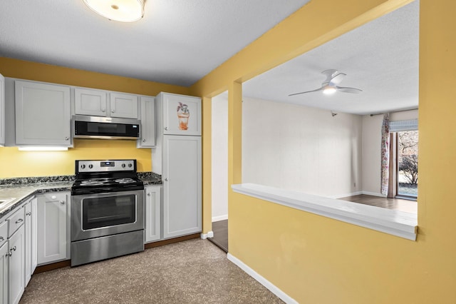 kitchen with baseboards, ceiling fan, stainless steel appliances, white cabinets, and dark countertops