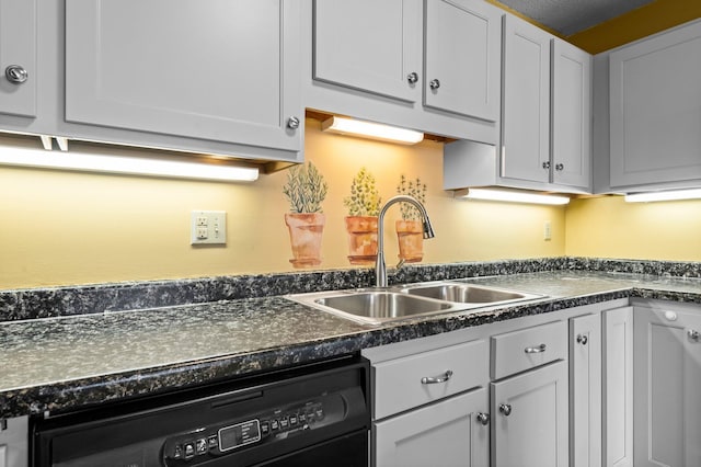 kitchen featuring dark countertops, white cabinets, black dishwasher, and a sink