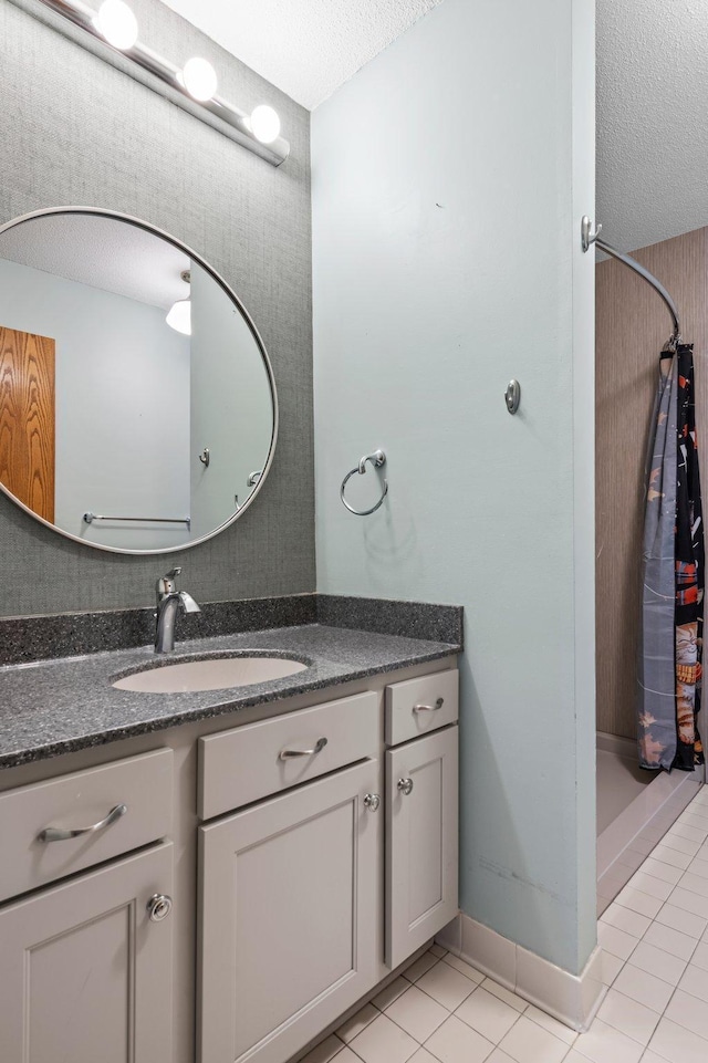 full bath featuring vanity, tile patterned floors, curtained shower, and a textured ceiling