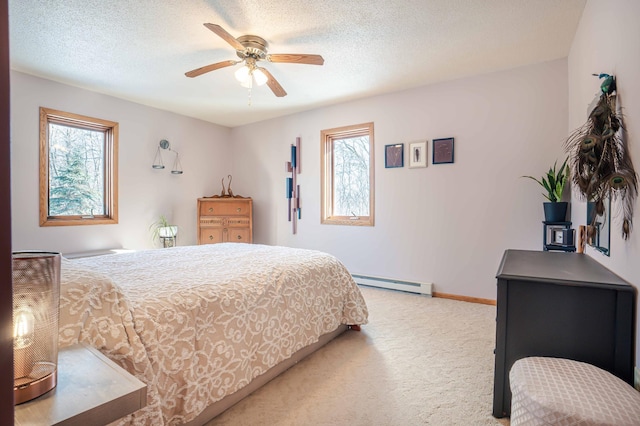 carpeted bedroom with a baseboard heating unit, baseboards, a textured ceiling, and a ceiling fan