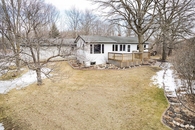 back of property with a deck, a yard, and a chimney