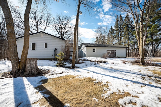 snow covered property with an outbuilding