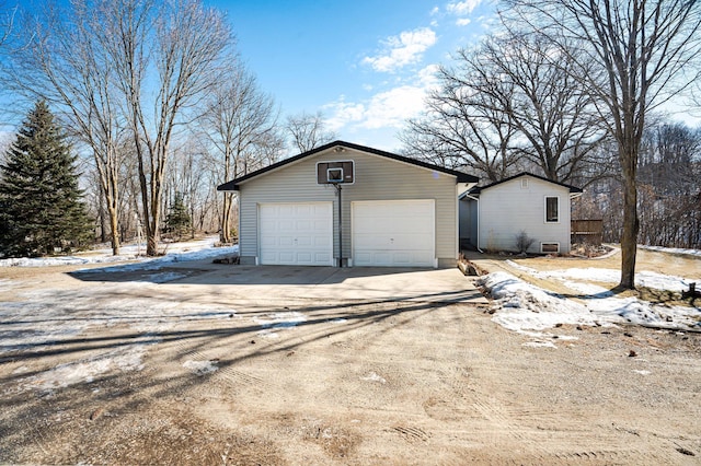 snow covered garage featuring a detached garage