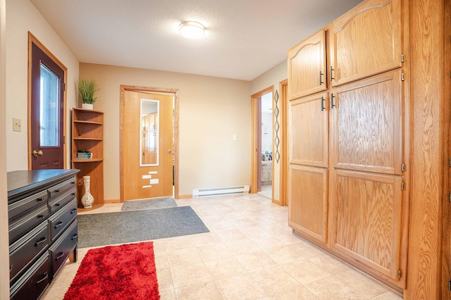 foyer with a textured ceiling, baseboards, and a baseboard radiator