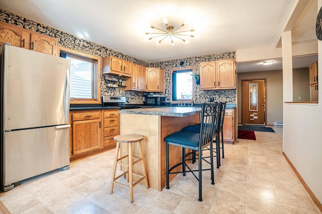 kitchen featuring a breakfast bar area, baseboards, stainless steel appliances, dark countertops, and tasteful backsplash