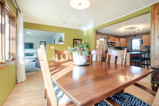 dining space featuring baseboards and light wood-style flooring