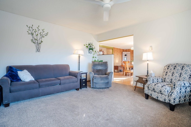 carpeted living area featuring a ceiling fan