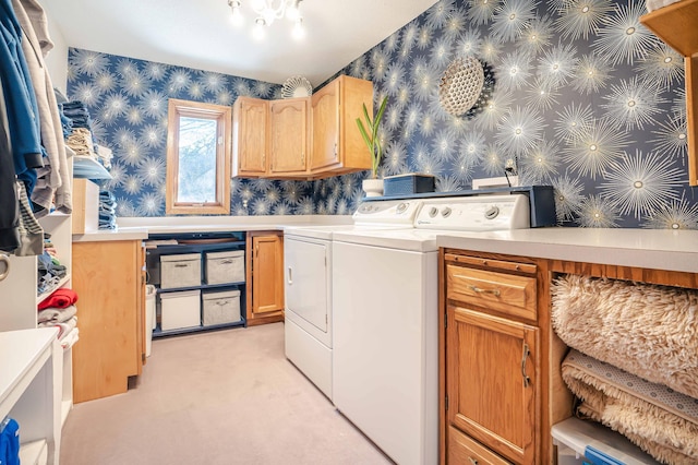 washroom featuring washer and dryer, cabinet space, and wallpapered walls