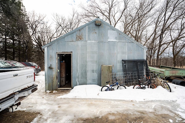 snow covered structure with an outbuilding