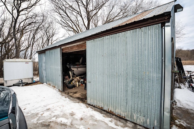 snow covered structure with an outbuilding