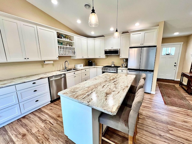 kitchen featuring visible vents, a sink, open shelves, range hood, and stainless steel appliances