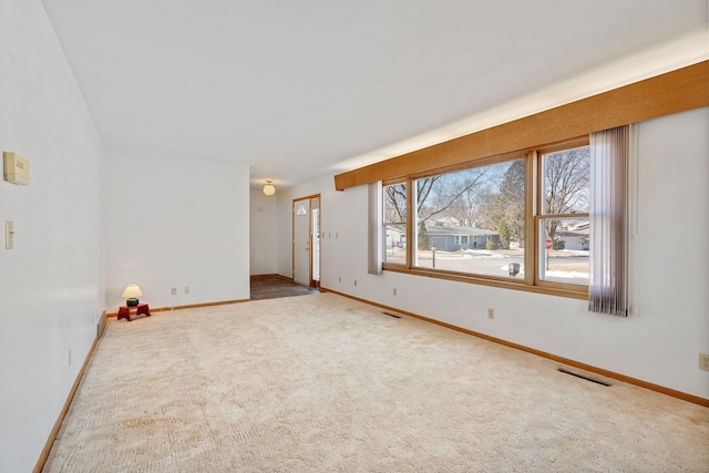 empty room with visible vents, carpet floors, and baseboards