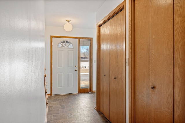 foyer entrance with stone finish floor and baseboards