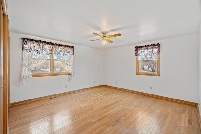 unfurnished room featuring visible vents, baseboards, ceiling fan, and light wood finished floors