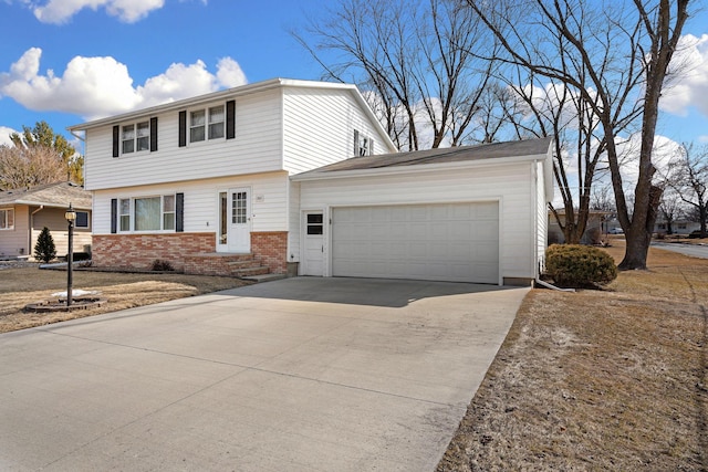 colonial home featuring a garage, brick siding, and driveway