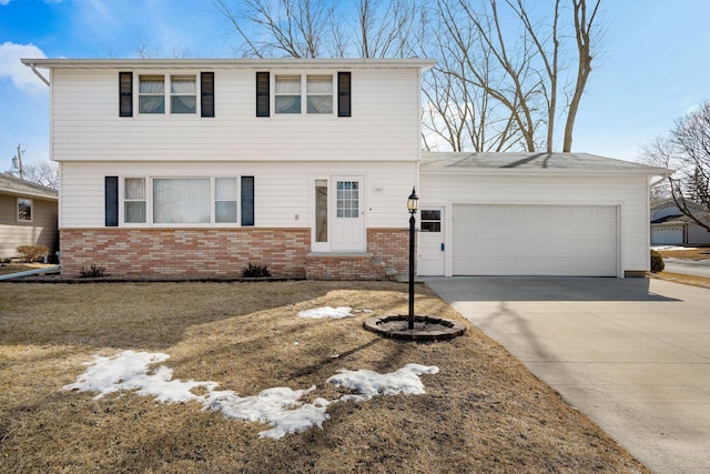 colonial home with entry steps, an attached garage, brick siding, and driveway