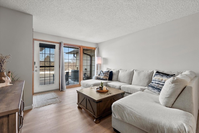 living room with light wood-style floors and a textured ceiling