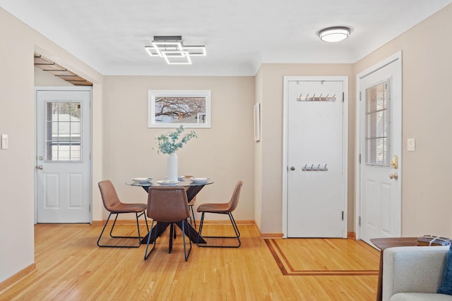 dining space with light wood-style flooring and baseboards