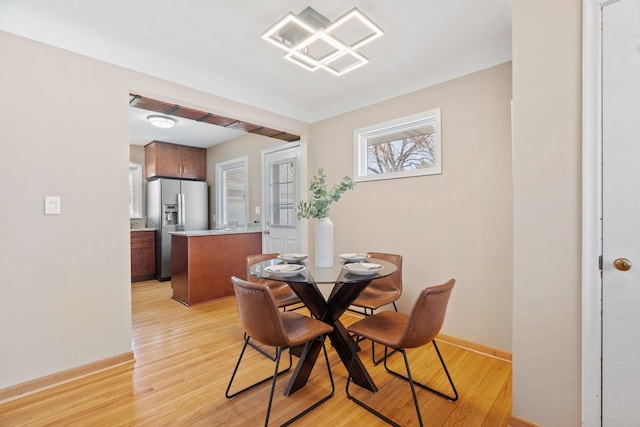 dining area with light wood-style floors and baseboards