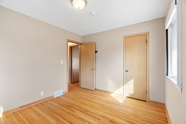 unfurnished bedroom featuring baseboards, visible vents, and light wood-type flooring