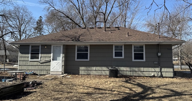 exterior space with a shingled roof and fence