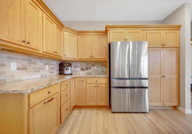 kitchen featuring light wood-style floors, light brown cabinets, and freestanding refrigerator