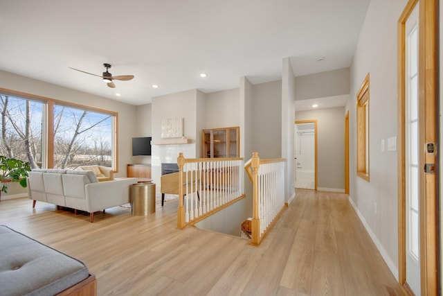 living room with recessed lighting, baseboards, and light wood-style floors