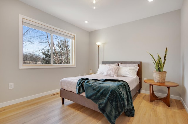 bedroom with recessed lighting, light wood-type flooring, and baseboards