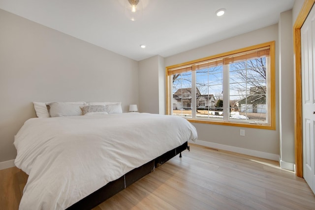 bedroom with recessed lighting, baseboards, and light wood finished floors