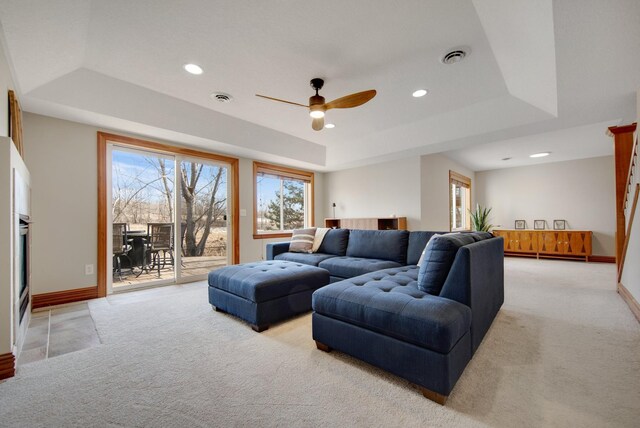 living room with visible vents, baseboards, a tray ceiling, recessed lighting, and light colored carpet