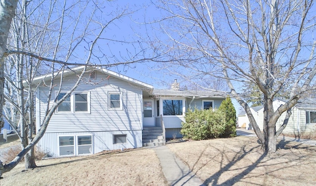 view of front facade featuring driveway and a chimney