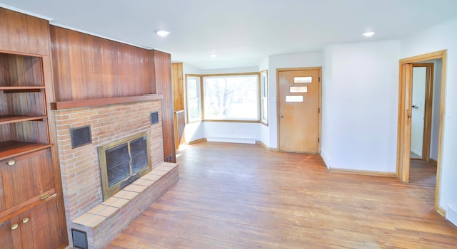 unfurnished living room featuring light wood finished floors, baseboards, baseboard heating, recessed lighting, and a fireplace