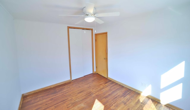 unfurnished room with ceiling fan, baseboards, and wood finished floors