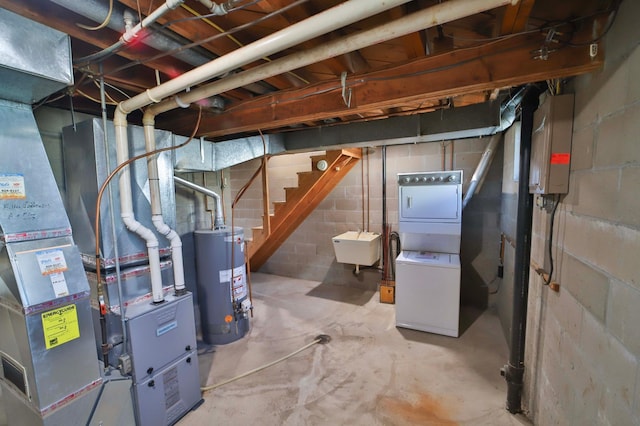 unfinished basement featuring stacked washer / dryer, stairway, gas water heater, electric panel, and a sink