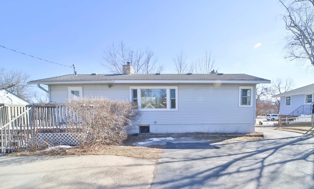 back of house featuring a chimney and a deck