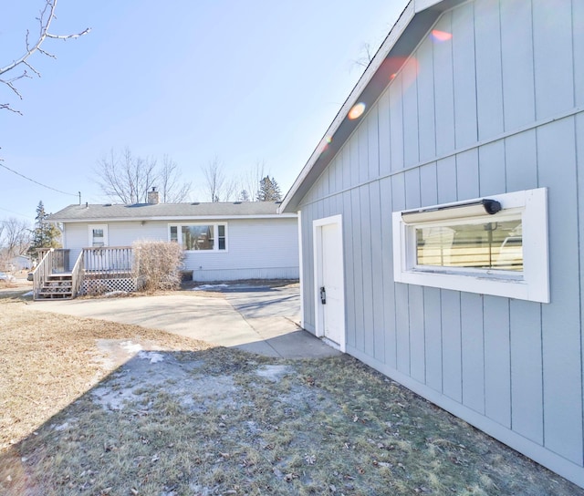 back of property with a deck and a patio