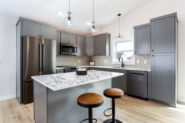 kitchen with tasteful backsplash, gray cabinets, appliances with stainless steel finishes, and a sink